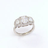 A platinum band ring with emerald cut diamonds set around the top edge.