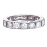 A platinum eternity band with large diamonds and engraved details.