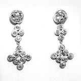 A pair of platinum diamond bezel set drop earrings displayed on a white surface.