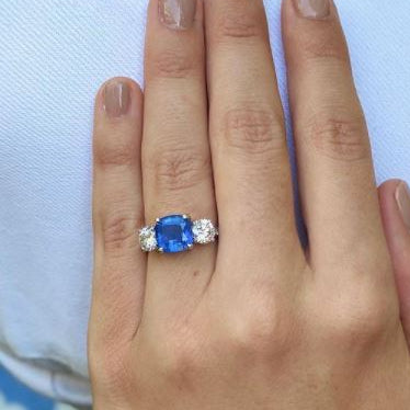 Woman wearing platinum cushion cut saphire and diamond custom designed ing 