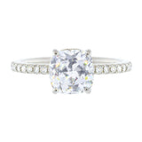 A platinum cushion cut diamond ring with smaller diamonds set around the band.