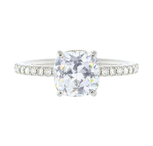 A platinum cushion cut diamond ring with smaller diamonds set around the band.