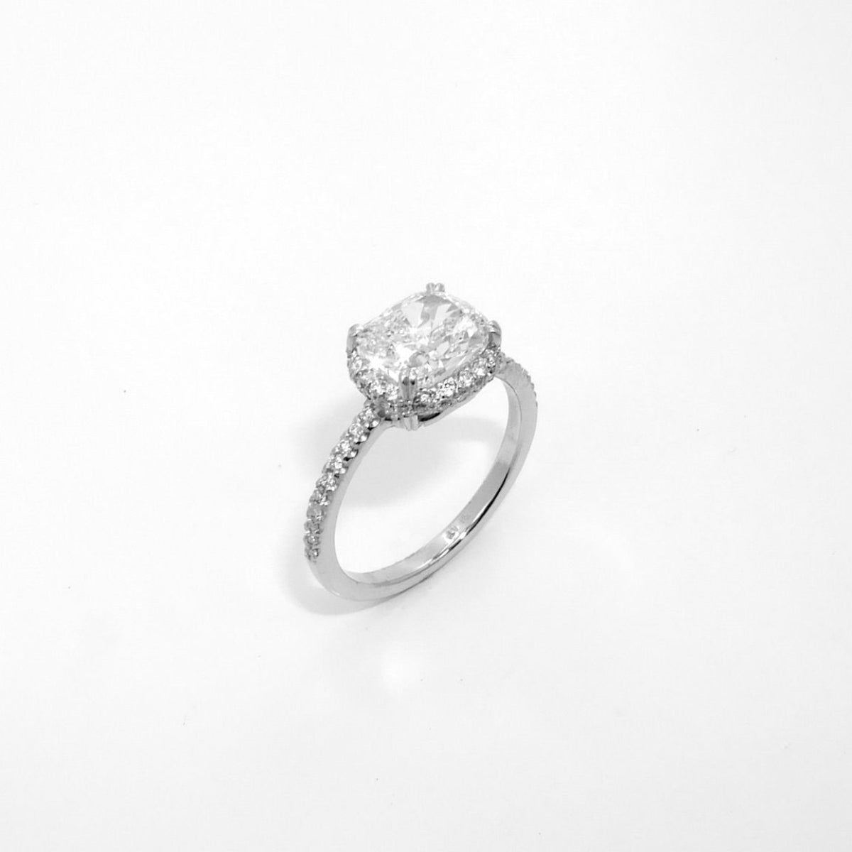 A platinum oval cut diamond ring with a halo effect, displayed against a white background.