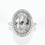 A platinum oval diamond halo ring with a clear, center diamond surrounded by smaller diamonds set in an oval pattern.