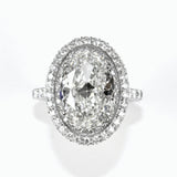 A platinum oval diamond halo ring with a clear, center diamond surrounded by smaller diamonds set in an oval pattern.
