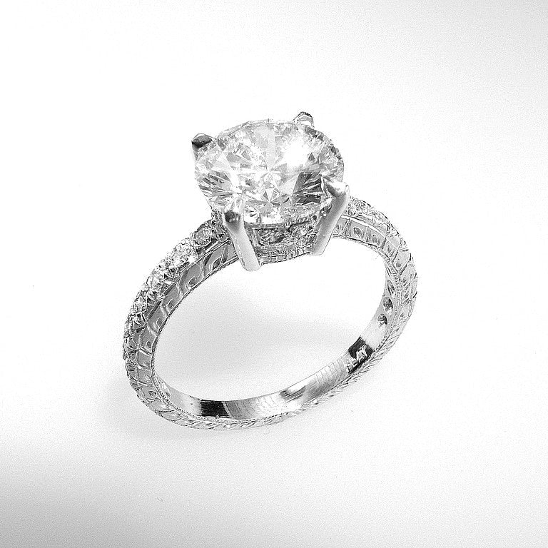Diamond ring with a large central gemstone and smaller stones on a white background