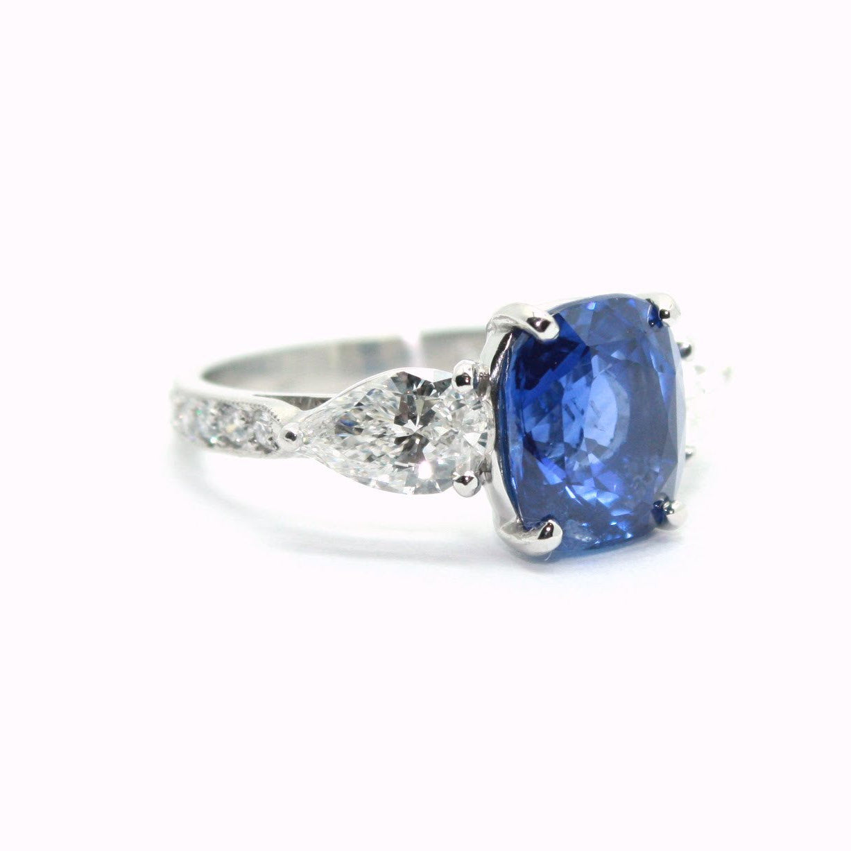 Platinum Ring with a blue sapphire gemstone and diamond accents on a white background