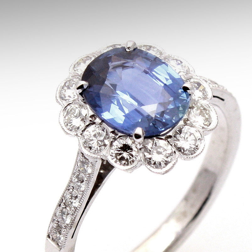 Platinum Ring with a blue sapphire gemstone and diamond accents on a white background