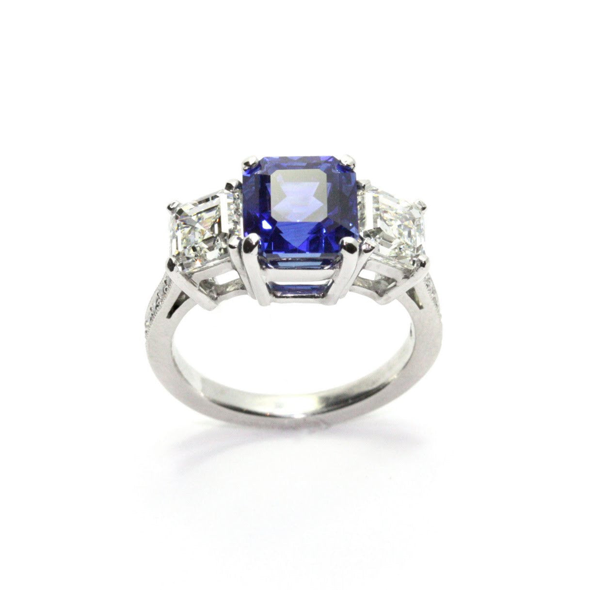 A platinum ring featuring a central sapphire stone with surrounding diamonds