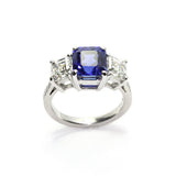 A platinum ring featuring a central sapphire stone with surrounding diamonds