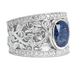 A platinum ring with a central blue sapphire stone, surrounded by smaller diamonds set in the band.