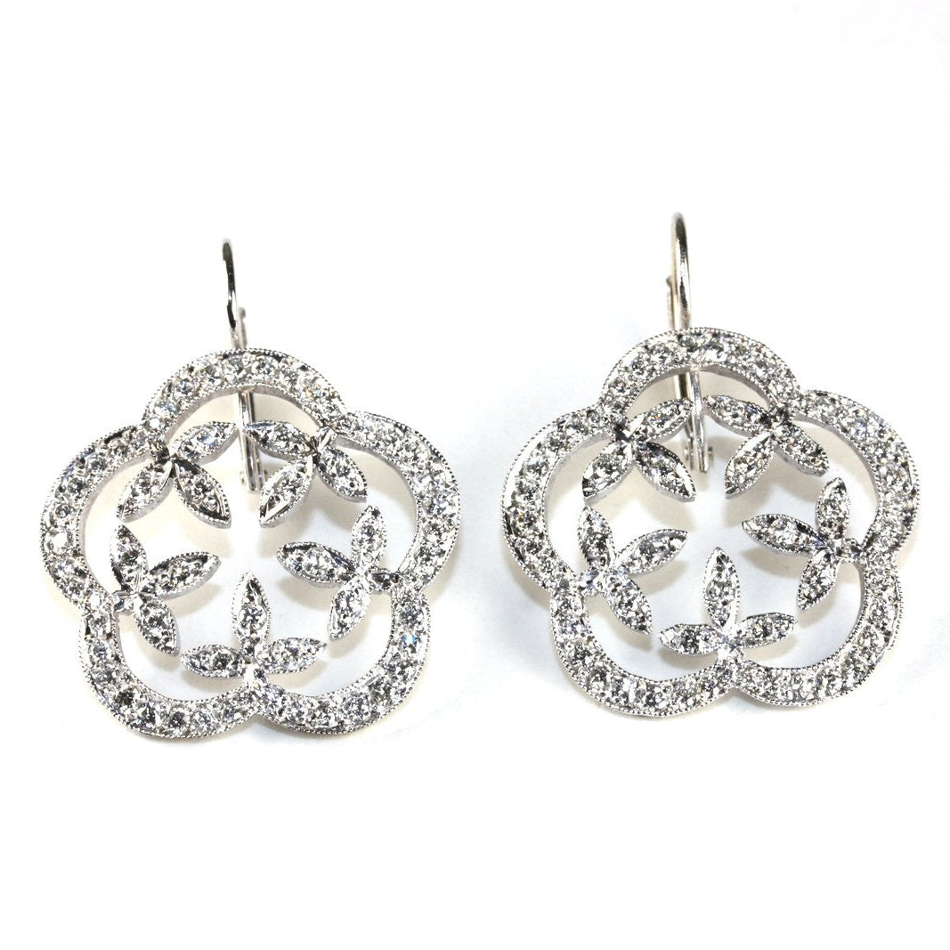 A pair of platinum and diamond garland drop earrings with a geometric pattern.