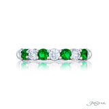 A JB Star platinum band ring with round diamonds and emeralds alternate placement