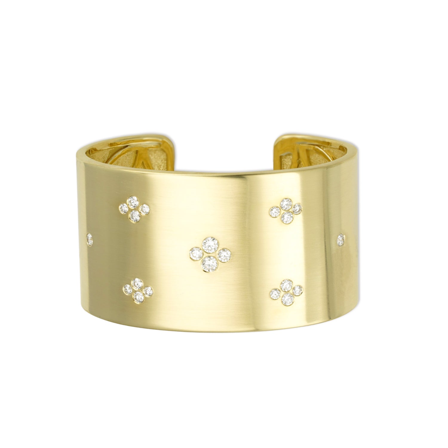 A gold cuff bracelet with multiple diamond accents.