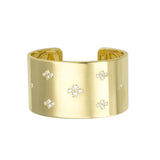 A gold cuff bracelet with multiple diamond accents.