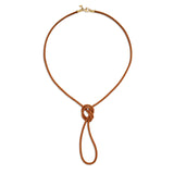 A brown leather cord necklace with a 18K yellow gold clasp designed by Temple St Clair