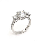 A custom three stone round brilliant diamond and platinum ring.