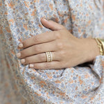 On model shot of 18K yellow gold and diamond band ring designed by Laura Pearce