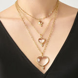 Woman wearing 3 sizes of Temple St Clair Heart Pendants